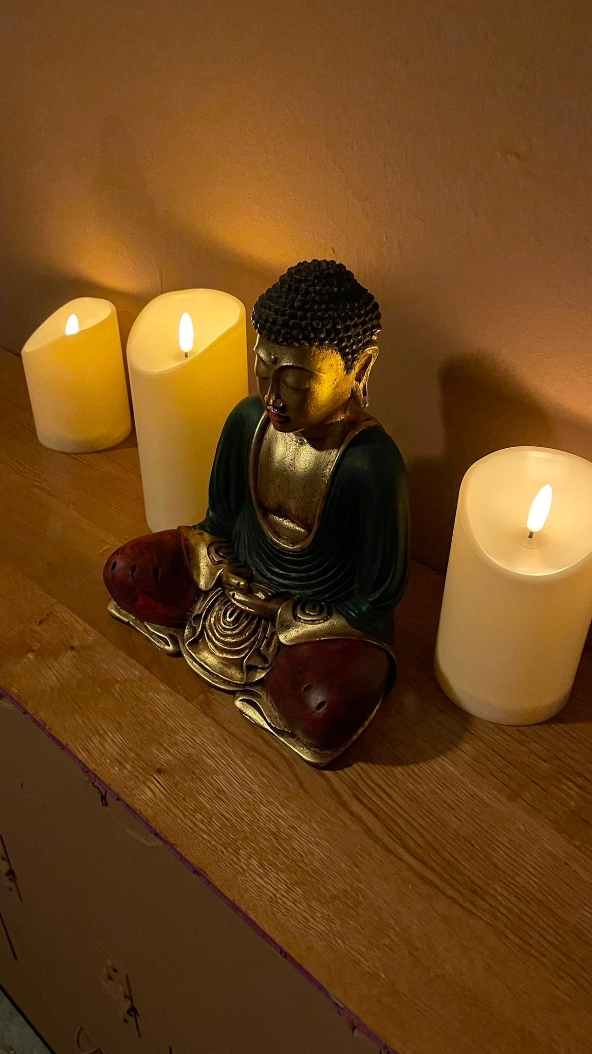 Buddhafigur und warmes Kerzenlicht im Studio